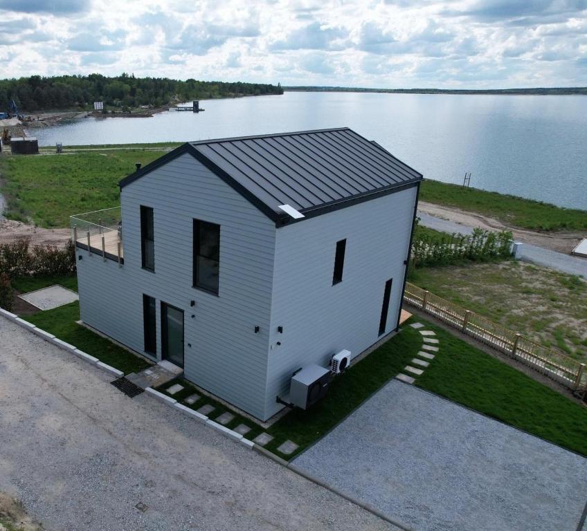 a small white house on the side of a lake at Ferienhaus Sonnenperle am Partwitzer See in Klein Partwitz