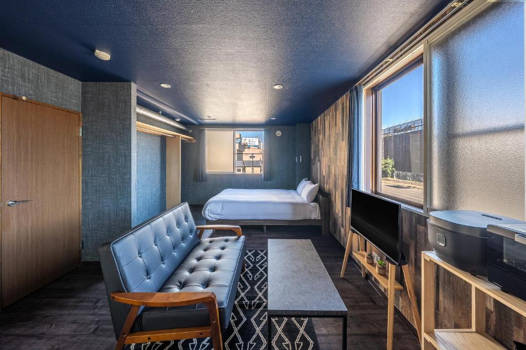 a room with a couch and a bed and a television at Silk Court 201 in Chitose