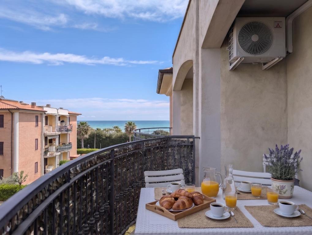 a table with a plate of food on a balcony at -1 min dal mare- AC balcone e garage in Pedaso
