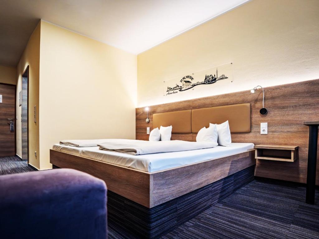 a bedroom with a large bed in a room at Hotel Zur Heide in Aachen