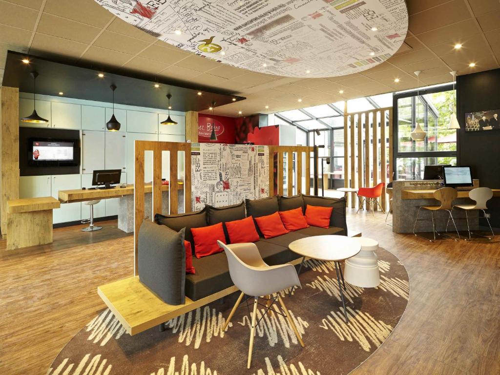 a living room with a couch and a table at ibis Marne La Vallee Champs-sur-Marne in Champs-sur-Marne