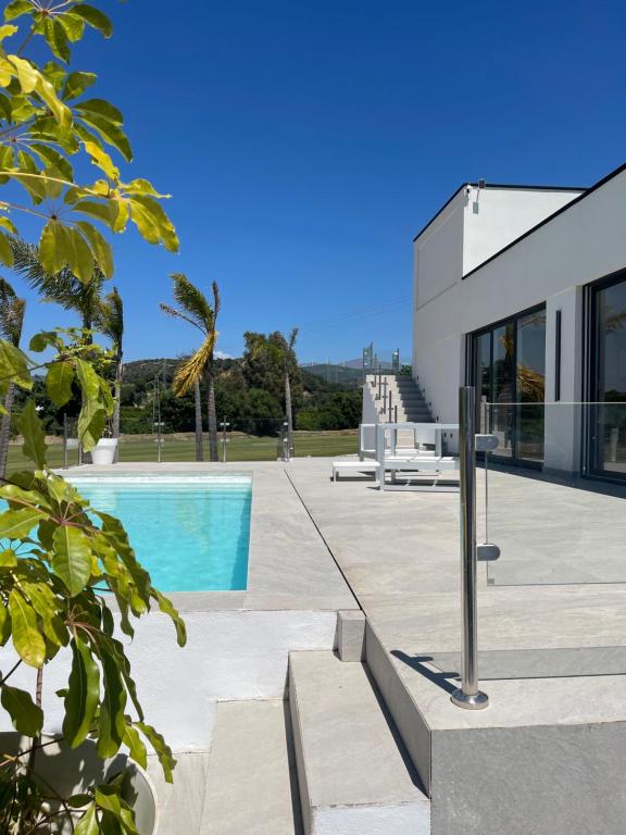 a villa with a swimming pool and a house at Sotogrande Polo Experience Luxury Villa in Sotogrande