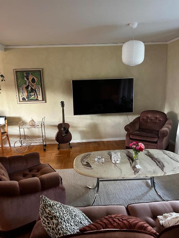 a living room with a couch and a table and a tv at Spacious house in cozy Kristdala in Kristdala
