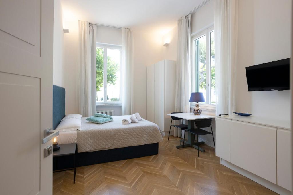 a bedroom with a bed and a desk and a television at SINONDA Luxury Apartment in Maiori
