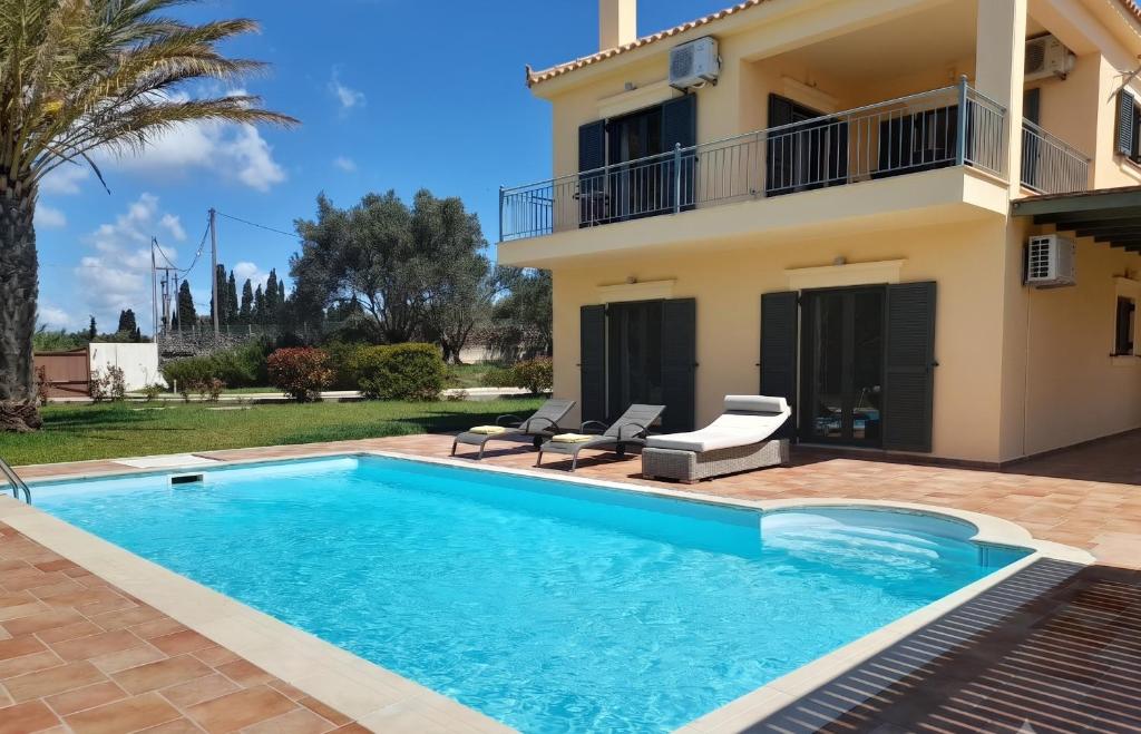 a villa with a swimming pool in front of a house at Private Pool Villas in Svoronata