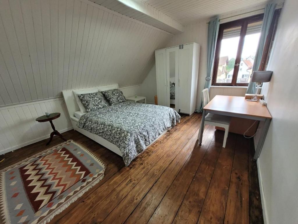 a bedroom with a bed and a table and a window at La Chambre Claire in Strasbourg