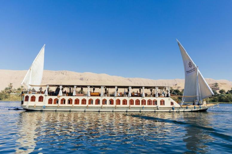 a boat with people on it on the water at Dahabiya Queen Tyi II in Luxor