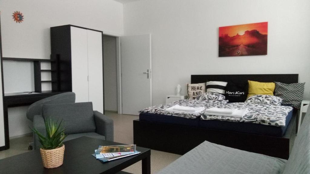 ブラチスラヴァにあるMari Kiri Penzionのベッドルーム1室(ベッド1台、ソファ、テーブル付)