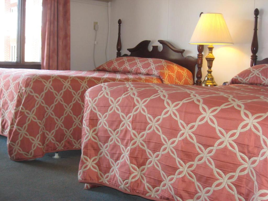 Postel nebo postele na pokoji v ubytování Lockport Inn and Suites