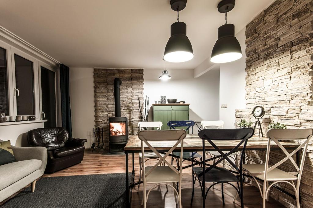 a living room with a table and chairs and a fireplace at Ski apartmán CHOPOK JASNA in Belá