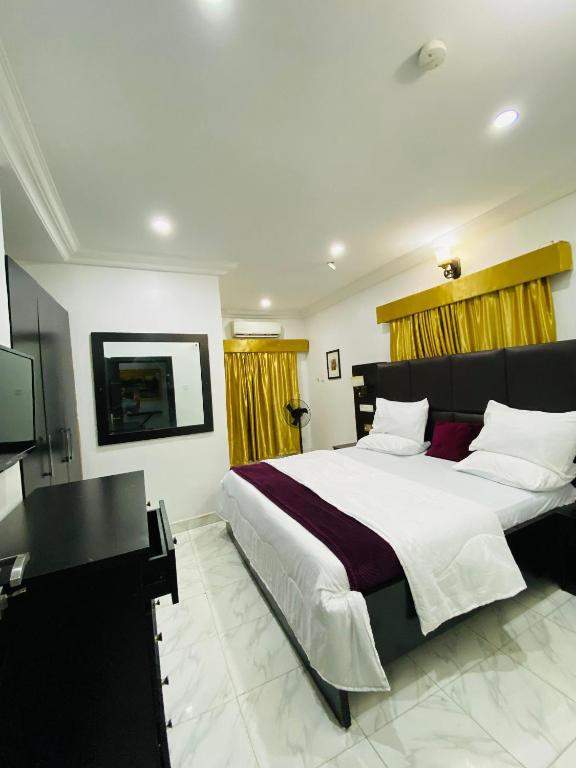 a bedroom with a large bed and a flat screen tv at Unique luxury duplex in Lekki