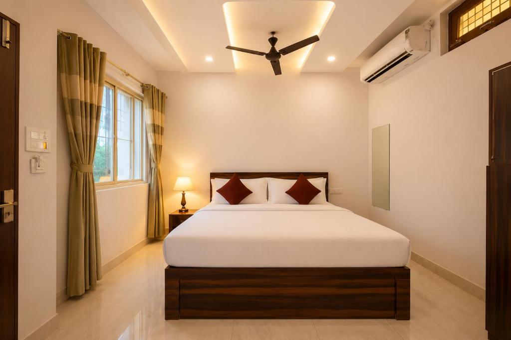 a bedroom with a bed and a ceiling fan at Shree Sita Sadan in Ayodhya