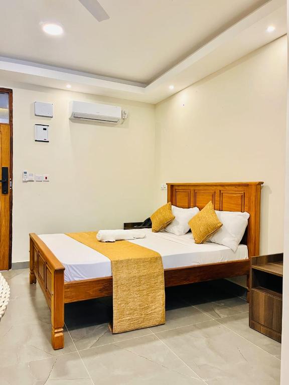 ein Schlafzimmer mit einem Holzbett und gelben Kissen in der Unterkunft Screenshot Hotel in Mtwapa