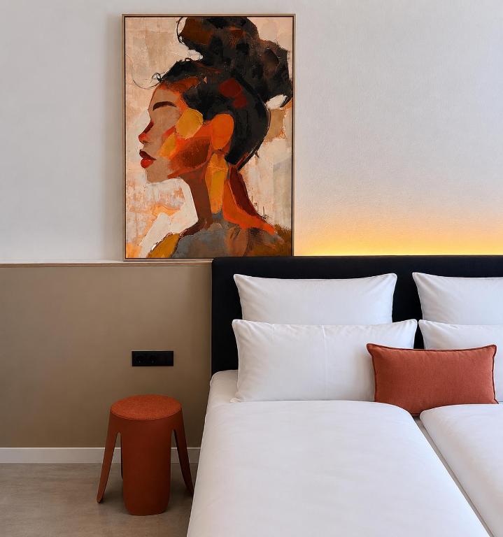 a bedroom with two beds and a painting on the wall at MY STAY - Smart Hotel in Mönchengladbach