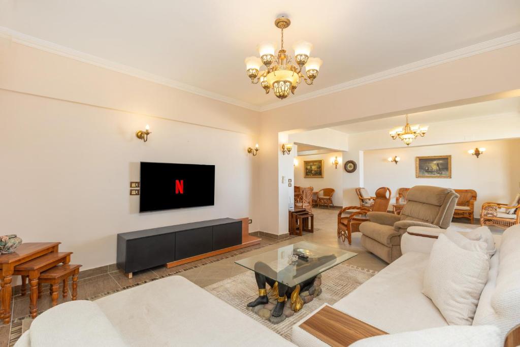 a living room with a couch and a tv at 3BR Beach Front Chalet On RedSea in Ain Sokhna