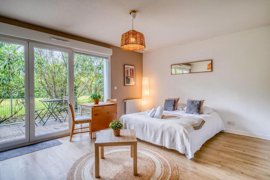 a bedroom with a bed and a table at Jardins de Flore in Mérignac
