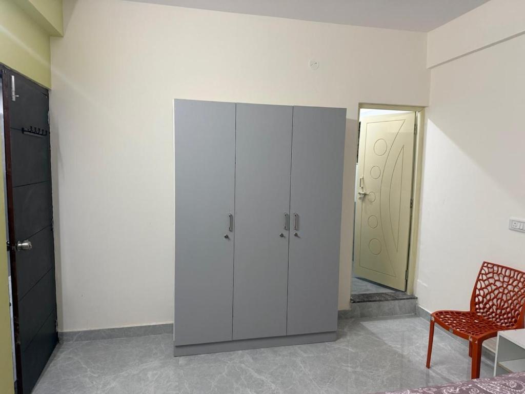 a room with a white cabinet and a red chair at VR Colive in Kammasandra