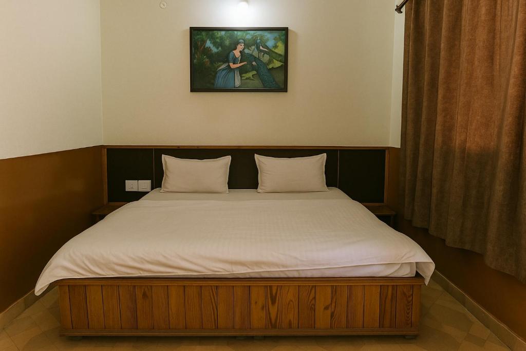 a bed in a bedroom with a picture on the wall at Chaman Vatika in Kasol