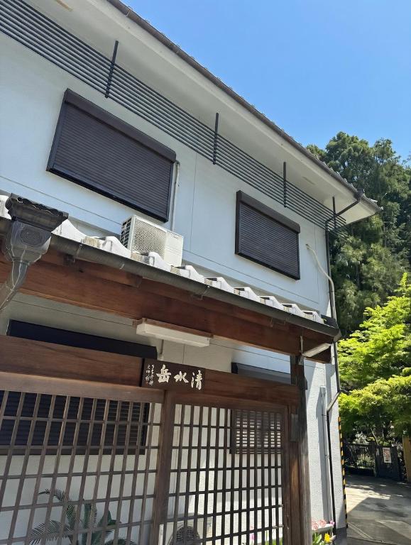 a building with two windows and a gate at KiyomizuGaku Guesthouse in Keage