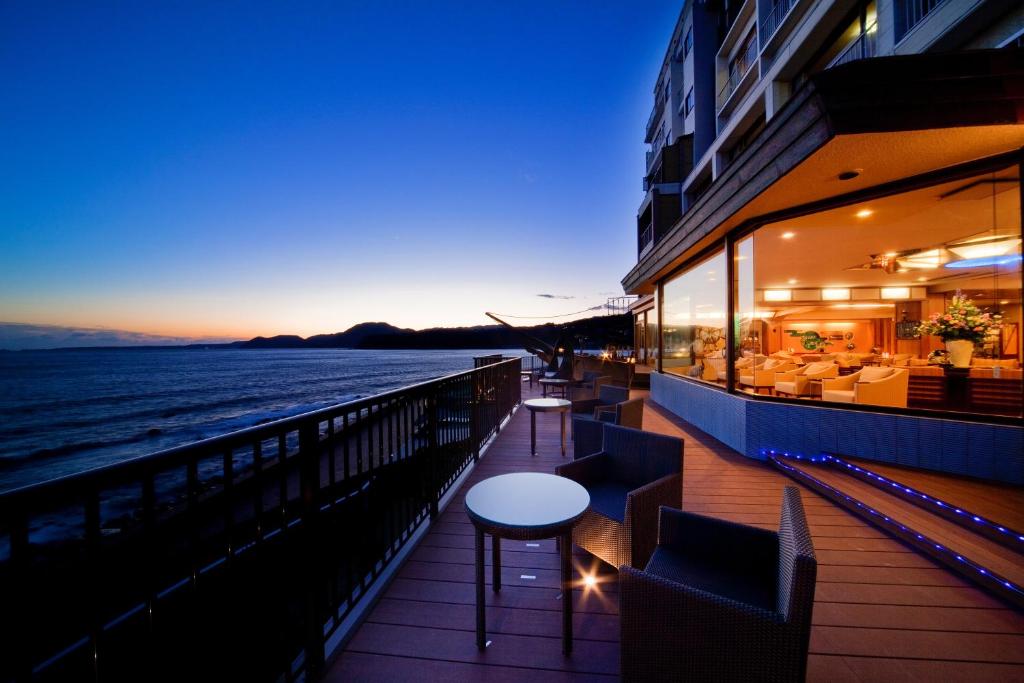 a balcony of a building with a table and chairs at Inatori Tokai Hotel Yuen in Higashiizu