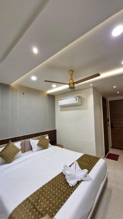 a bedroom with a white bed with a ceiling fan at Hotel Akshara Inn in Nasīrābād