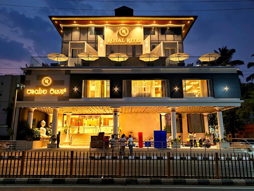 a building with people sitting in front of it at Royal Ritis in Shimoga