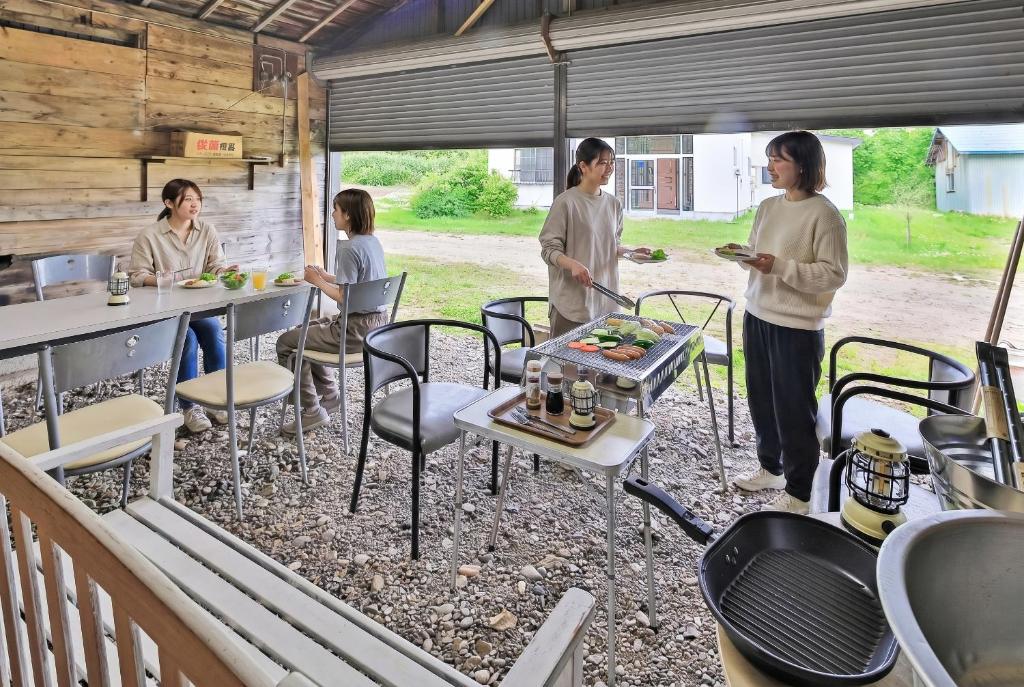 a group of people standing around a table with food at Cottage Abashiri in Abashiri