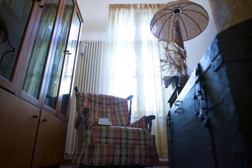 a living room with a chair and a window at Appartamento Le Corti 2 in Alessandria