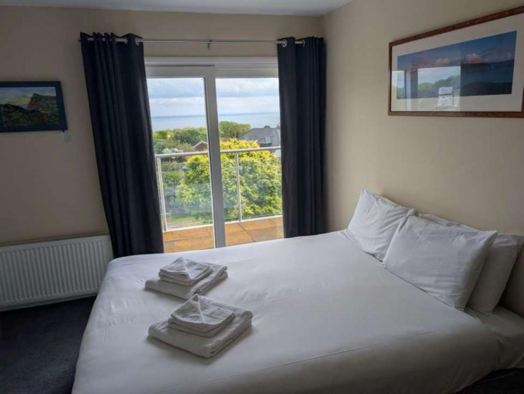 a bedroom with a white bed with towels on it at Coastguard cafe room 2 in Hastings