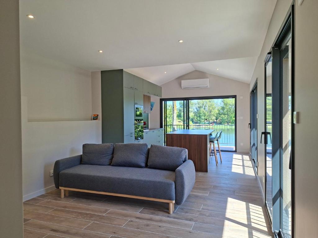 a living room with a couch and a kitchen at Maison du Bord du Rhône in Saint-Pierre-de-Boeuf