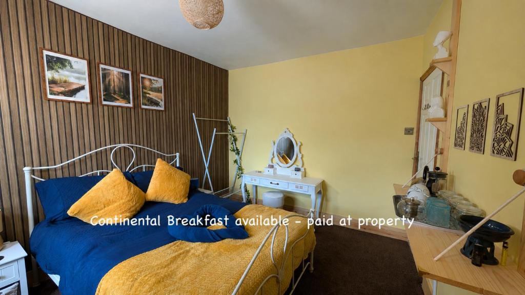 a bedroom with a bed with blue sheets and a mirror at Hot Tub Home - Stay in Stoke on Trent