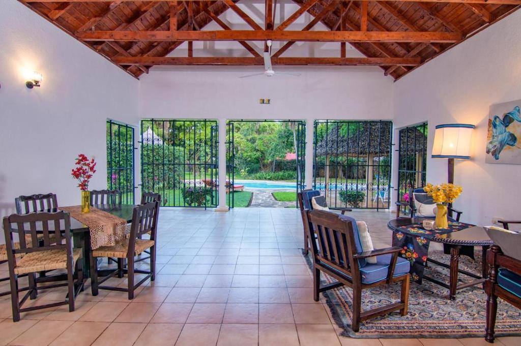a living room with a table and chairs and sliding glass doors at Driftwood Beach Malindi Palace in Malindi