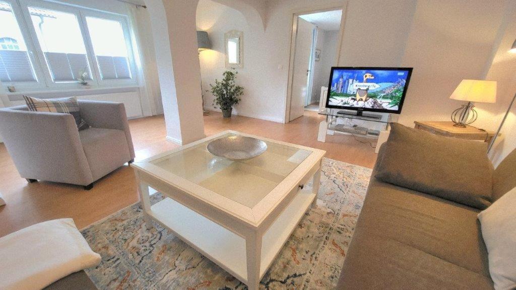 a living room with a table and a tv at Ferienhaus Friedrich-Borge-Straße in Kühlungsborn