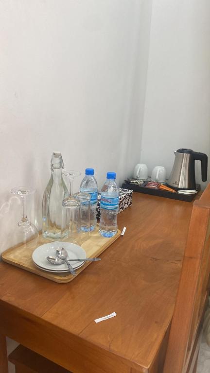 a wooden table with a plate and bottles of water at Simai house in Nungwi