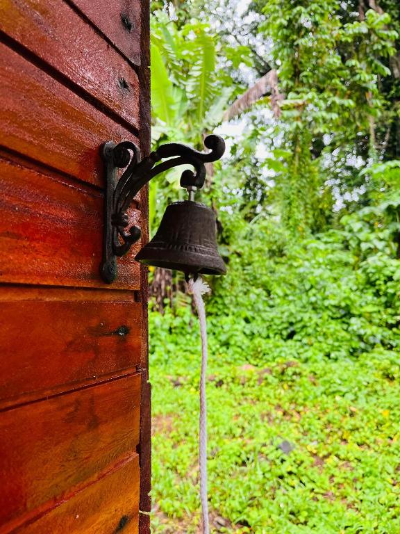 a bell hanging on the side of a wooden door at Casa do Príncipe in Santo António