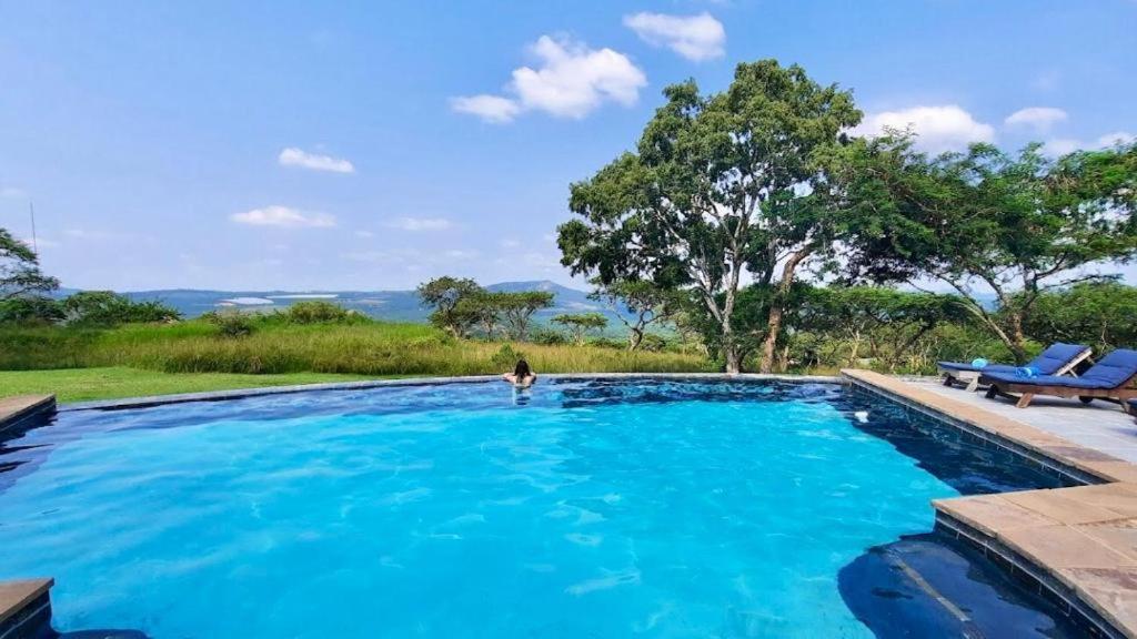 a person standing in a large blue swimming pool at Muluwa Lodge in White River