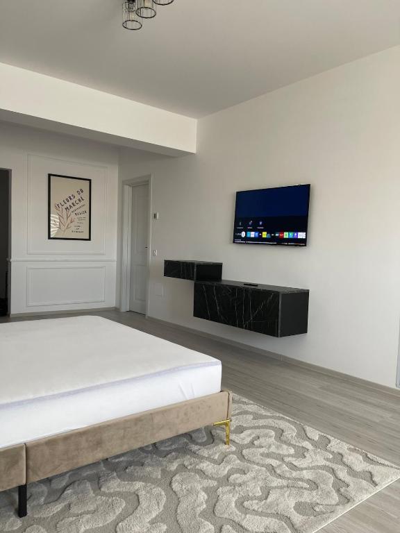 a bedroom with a bed and a flat screen tv at Soho Studio Fial in Bacău