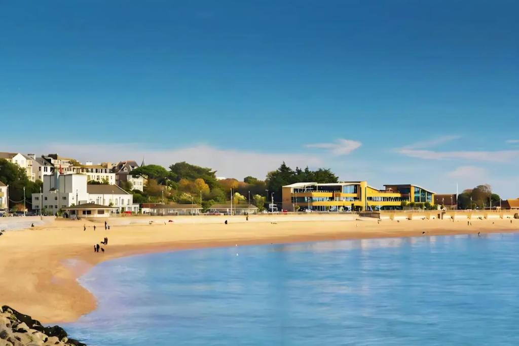 a beach with a group of people walking on the sand at Jurassic Coast Gateway Exmouth Escape in Exmouth
