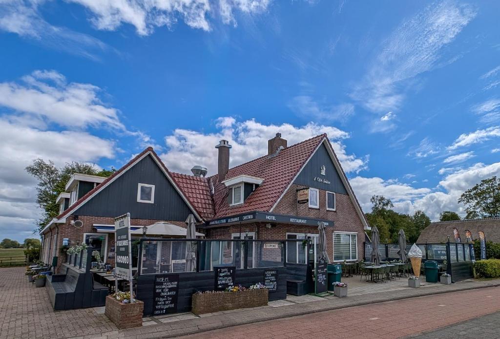 a building on a street with a blue sky at Hotel B&B d'Olde Smidse in Giethoorn