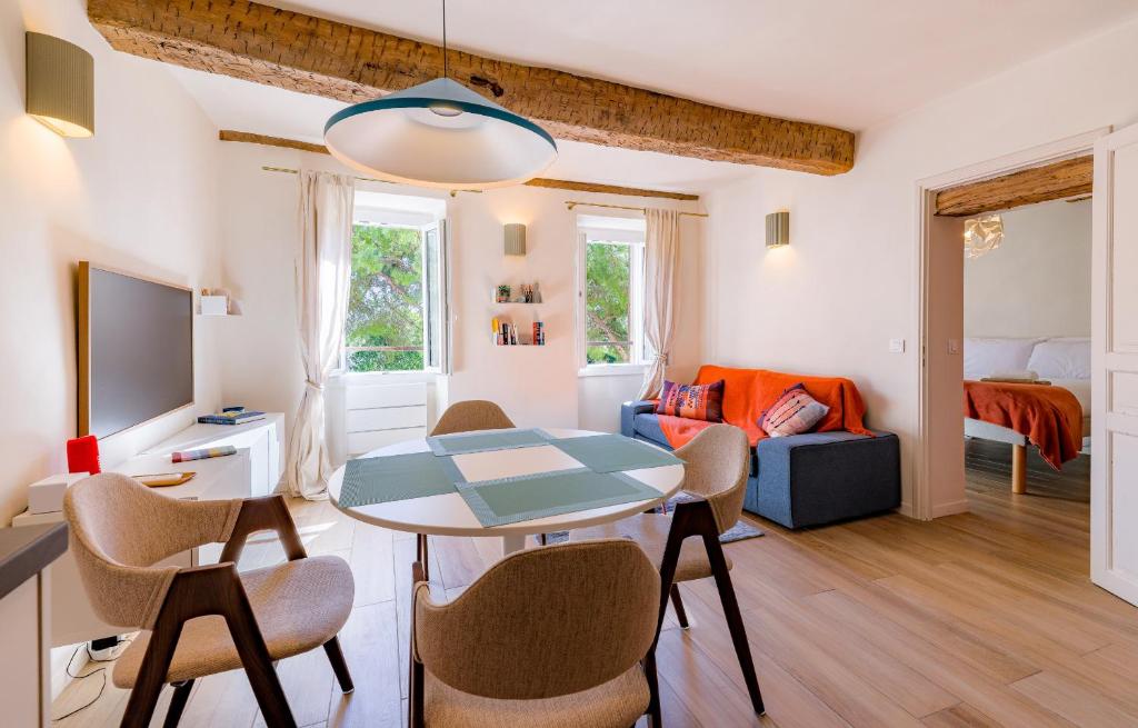 a living room with a table and chairs and a couch at Apt Libelule in Tourrettes-sur-Loup