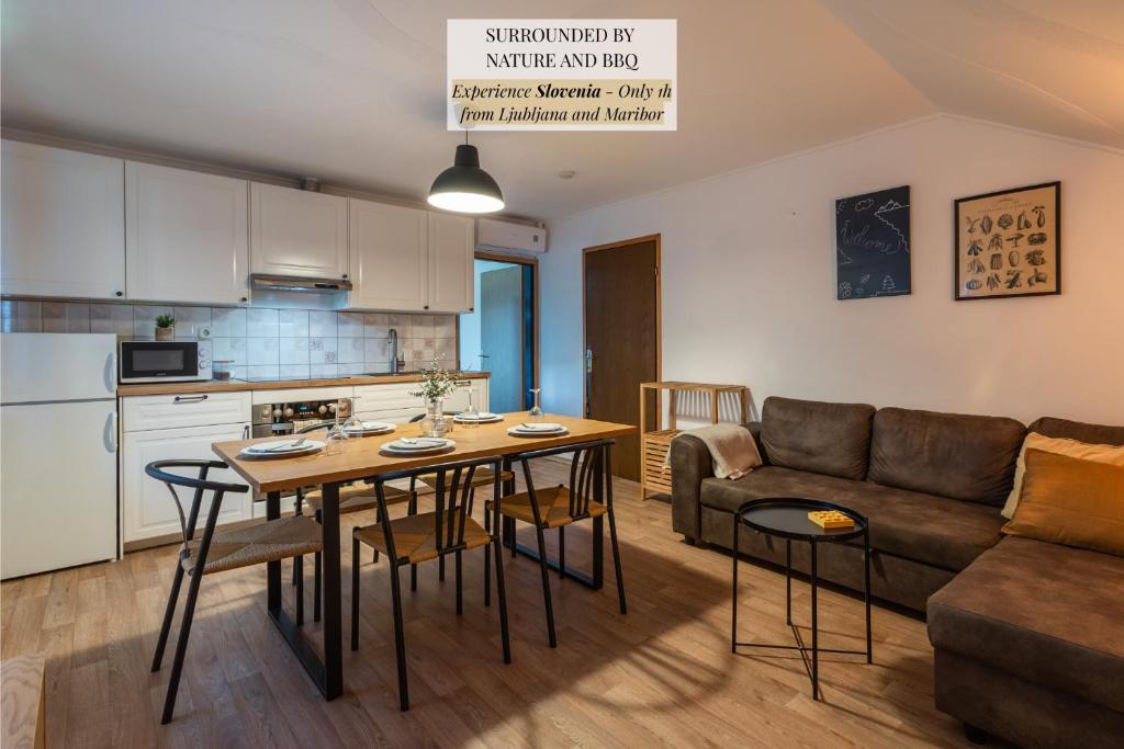 a kitchen and living room with a table and a couch at Apartments Orel in Mozirje