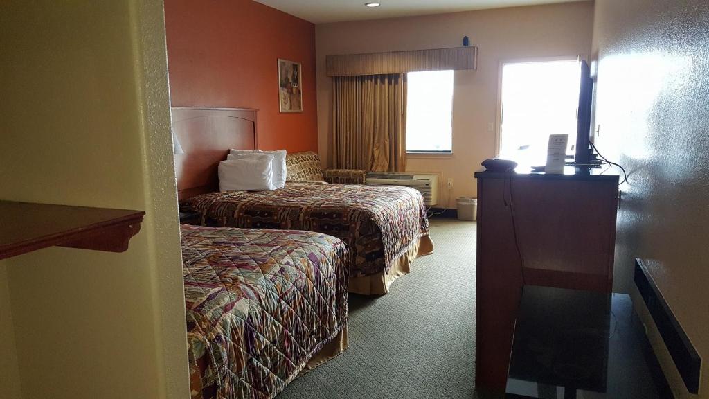 a hotel room with two beds and a window at Budgetel Inn and Suites in Hearne