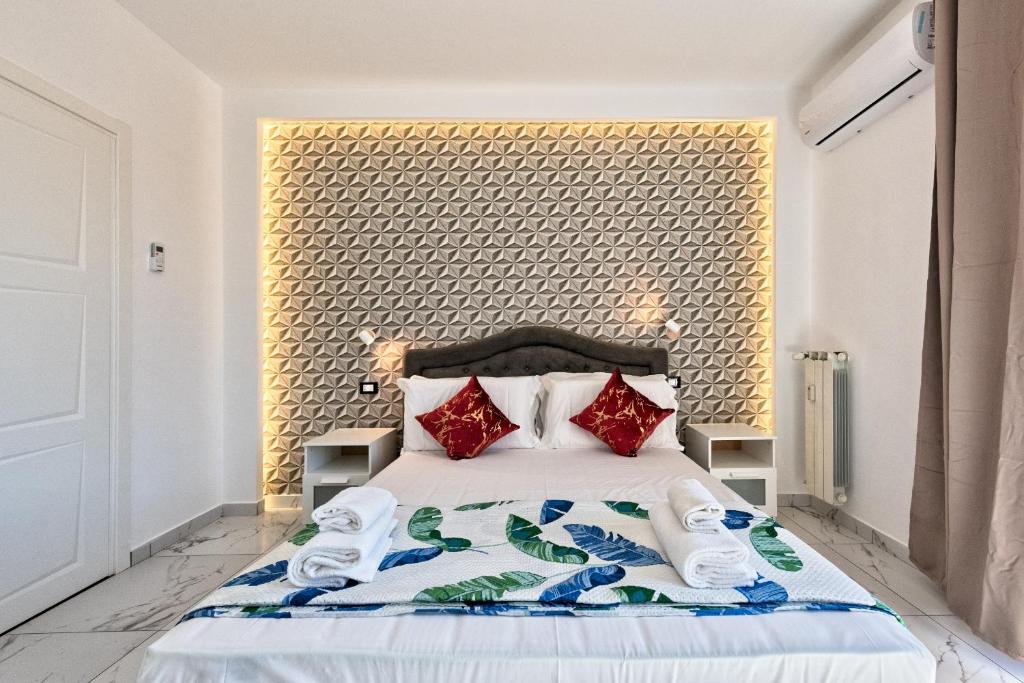 a bedroom with a large bed with red pillows at Sara Venice station in Mestre