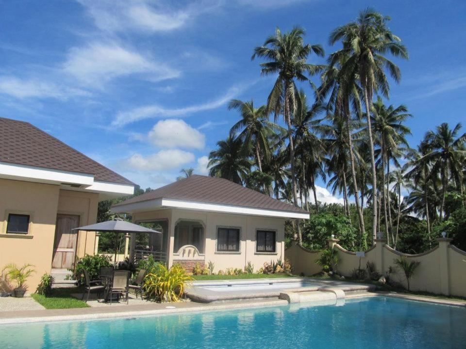 a house with a swimming pool in front of a house at Ucoy Beach Resort in Libertad