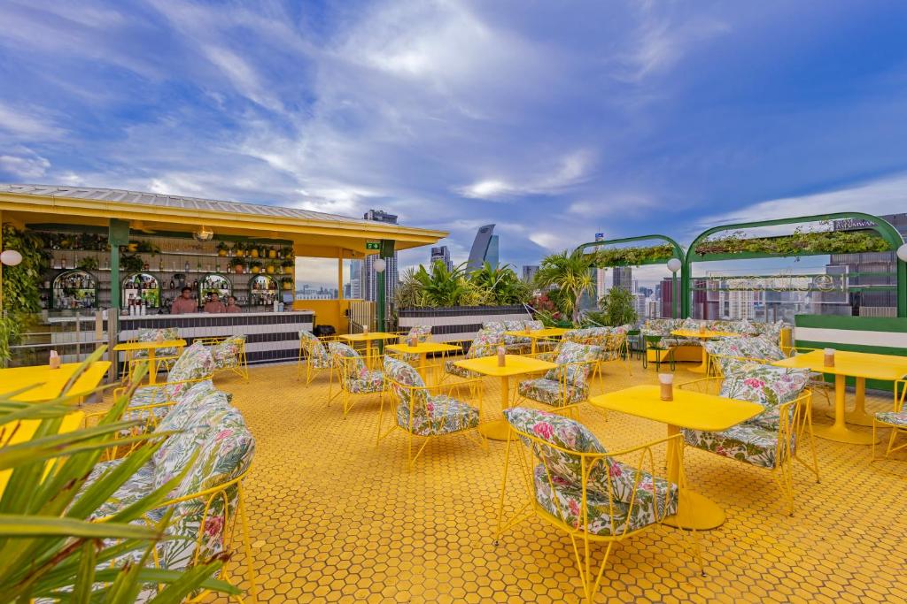 a patio with tables and chairs on a roof at Siam At Siam Design Hotel Bangkok in Bangkok