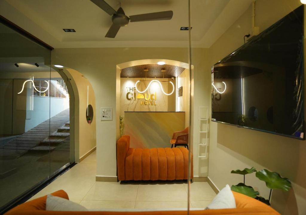 an orange couch in a room with a mirror at TheCloud Hotel in Nizāmābād