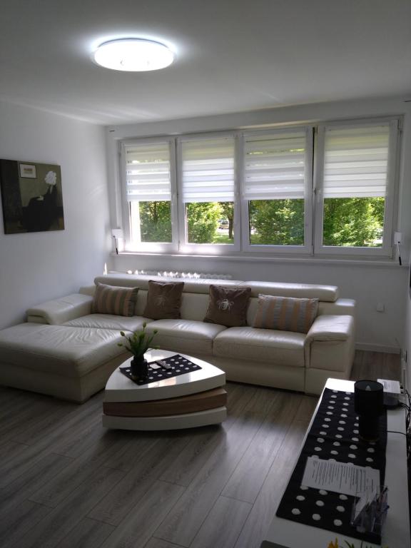 a living room with a white couch and windows at MG Apartament Elfów in Tychy
