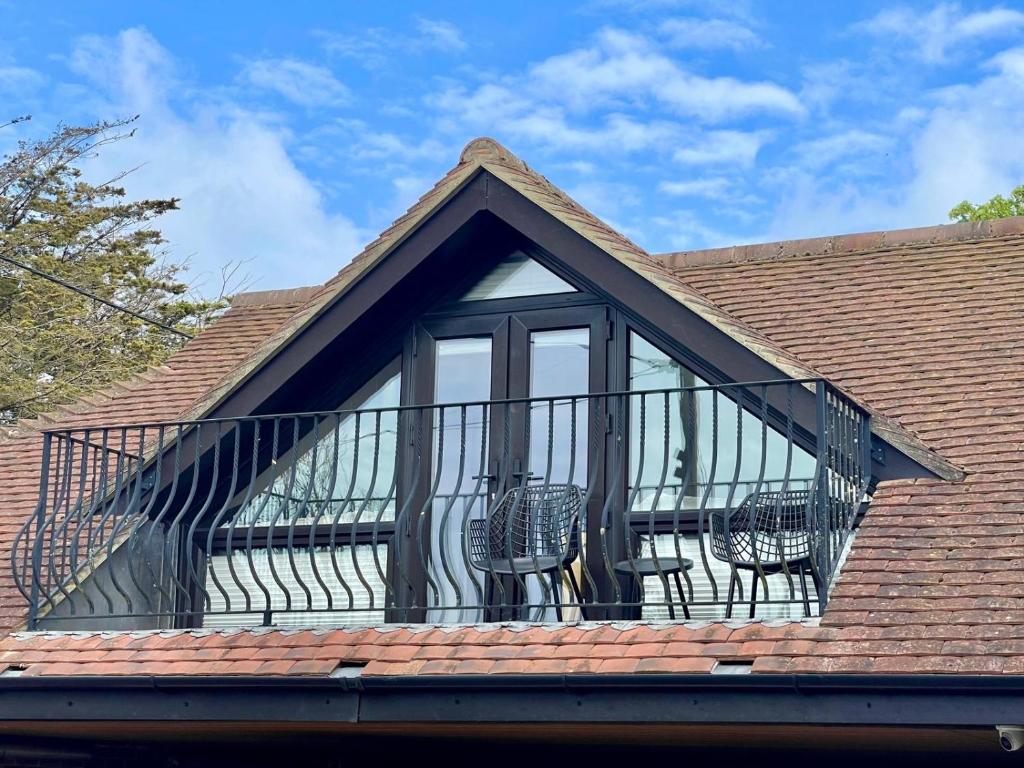 a balcony with chairs on top of a roof at Hunters Hide Apt in Littlehampton