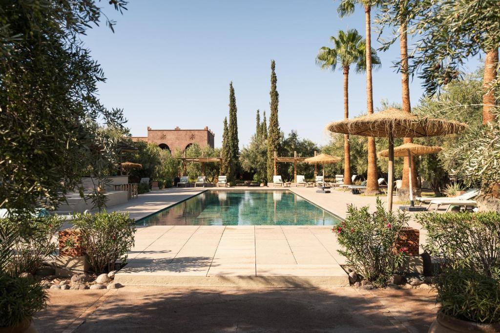 a swimming pool with umbrellas and a resort at Domaine de Tameslohte in Tameslouht