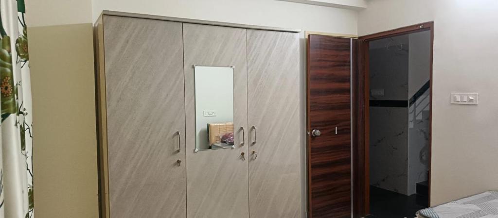 a large wooden cabinet in a room with a mirror at Happy Ladies PG in Kammasandra